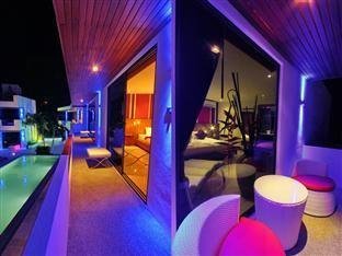 Colourful night lighting along a covered terrace beside the pool at Beluga Boutique Hotel