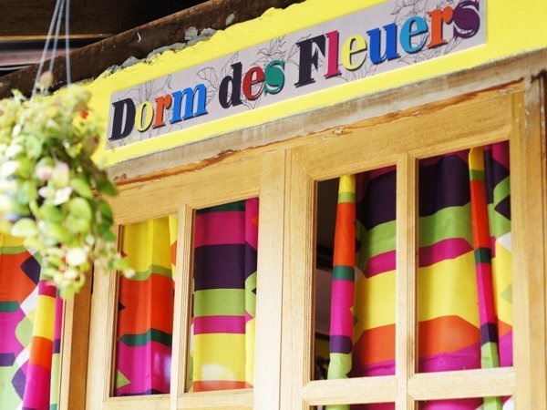 Colourful curtains beneath the Dorm des Fleurs entrance sign