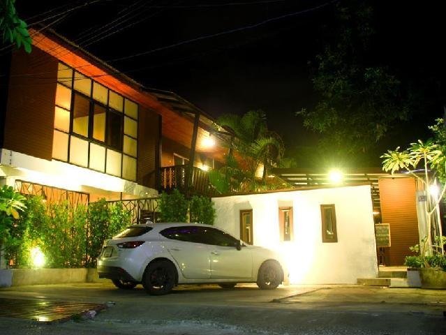 Ganesha House frontage and parked car illuminated at night