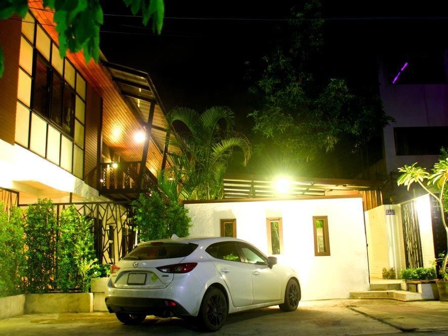 Nighttime view of the guesthouse entrance, plants and building facade