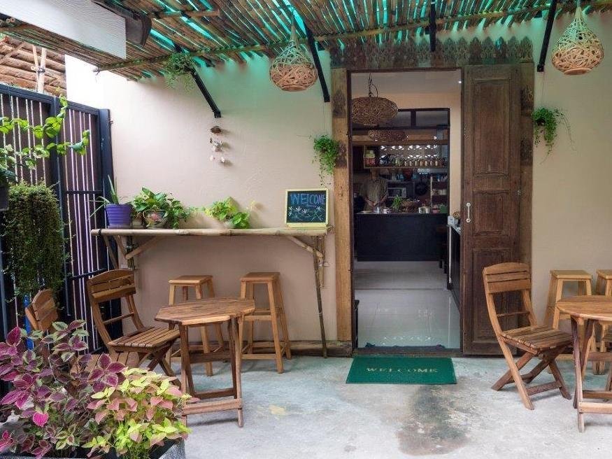 Plant-filled seating area and entrance at Kaysorn Residence