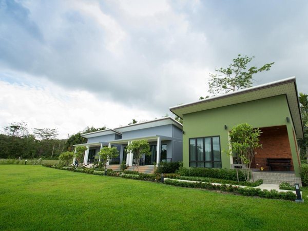 Low buildings and cottage terraces facing a lawn at Moonlight Cottage