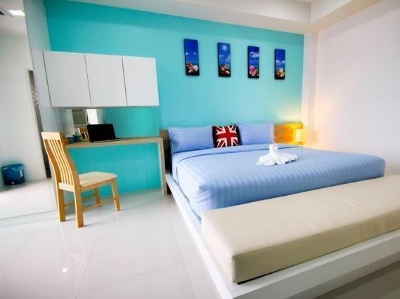 Double bed, desk and wall cabinets against a turquoise wall in an S5 room