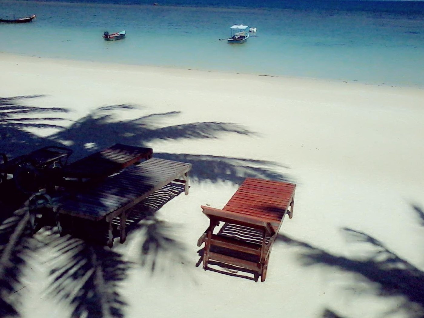 Beach lounger and coastal water in a Silver Beach Bungalow listing photograph