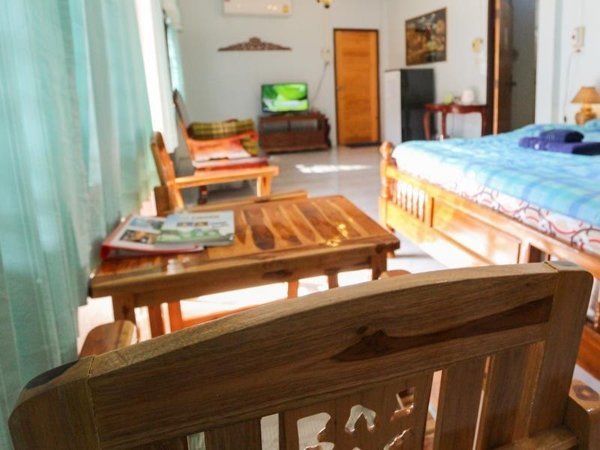 Wooden seating and a bed inside a room at The Stay Guest House